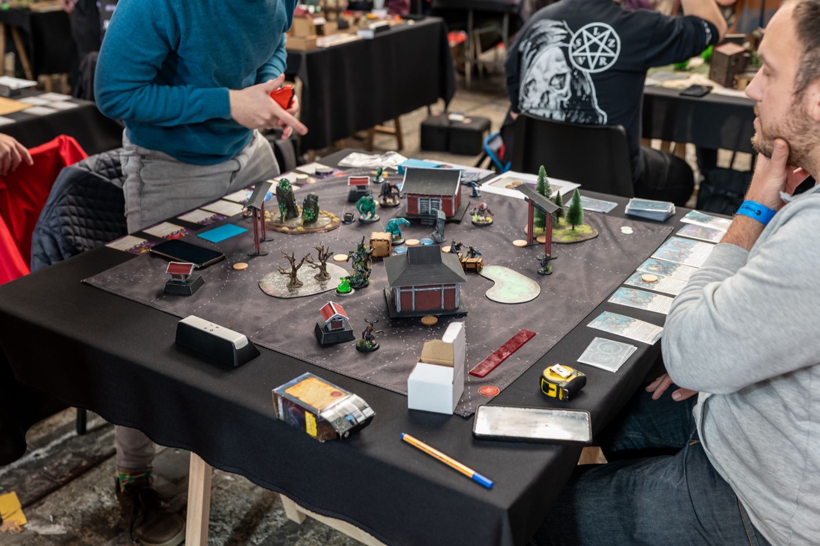 Joueurs de cartes attablés pendant un tournoi en boutique