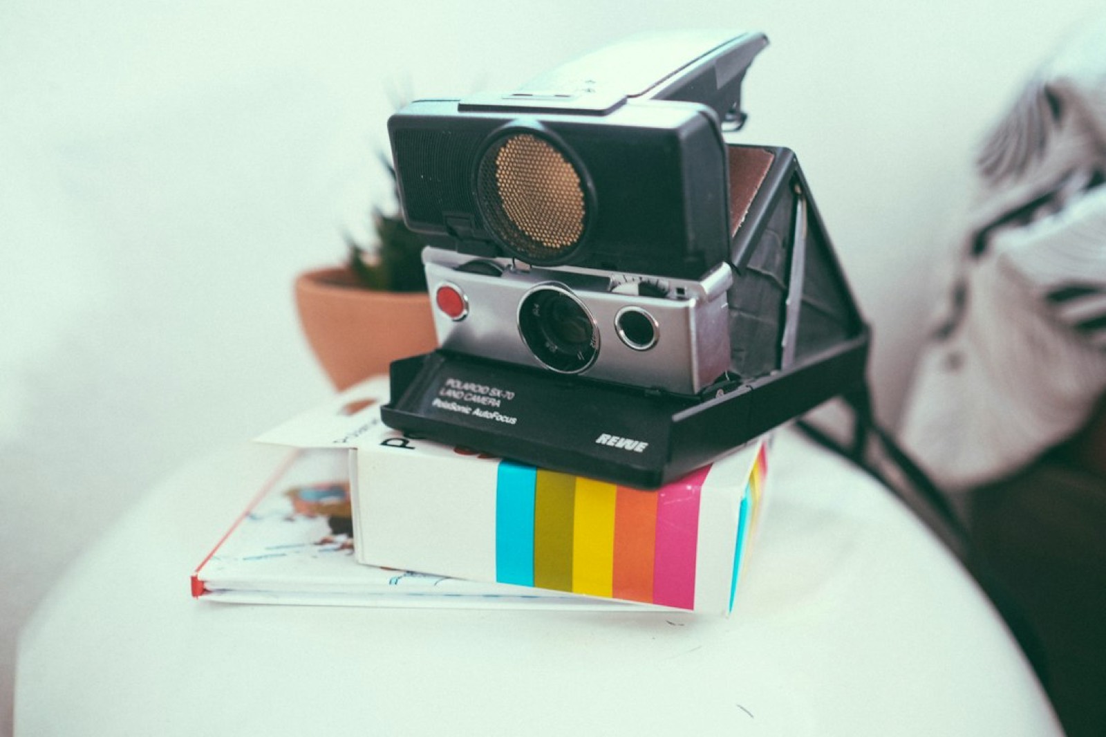 Appareil photo instantané et tirages posés sur une table, clin d'œil à Max Caulfield, photographe dans Life is Strange